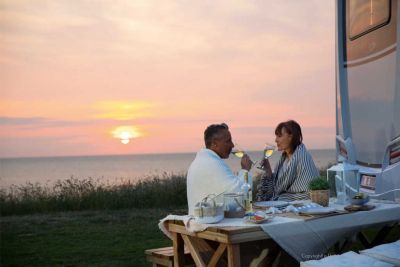 Romantischer Sonnenuntergang vor dem Camper Premium Plus von McRent Deutschland