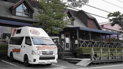 Der Kuga Camper von Travellers Autobarn in Japan vor einem Restaurant